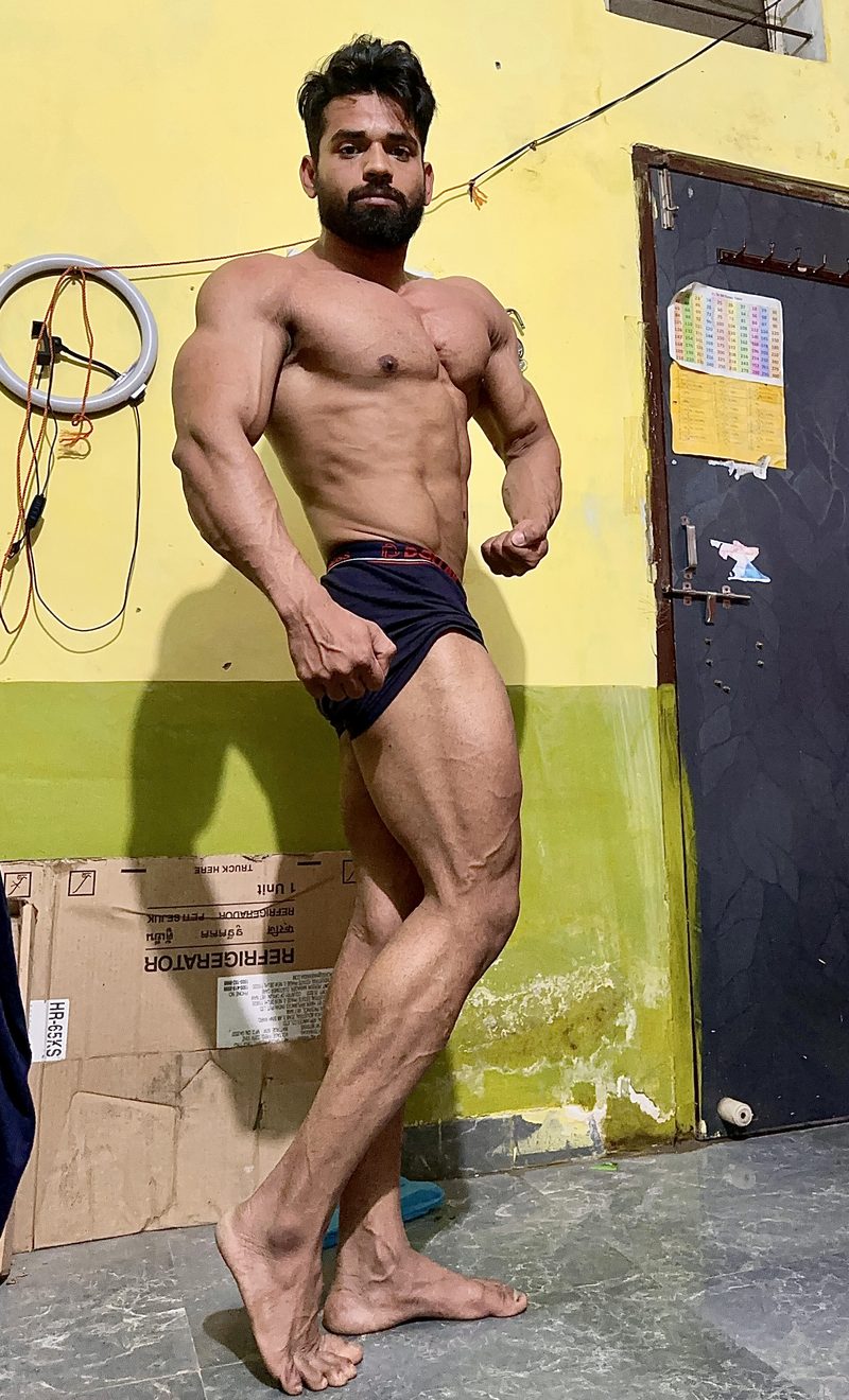 Amit in a side chest pose showing full-body conditioning