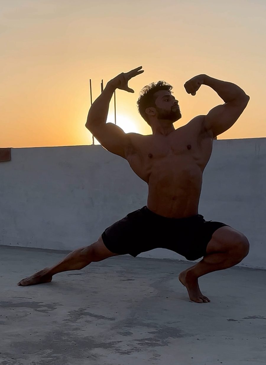 Amit holding a classic pose on a rooftop at sunset