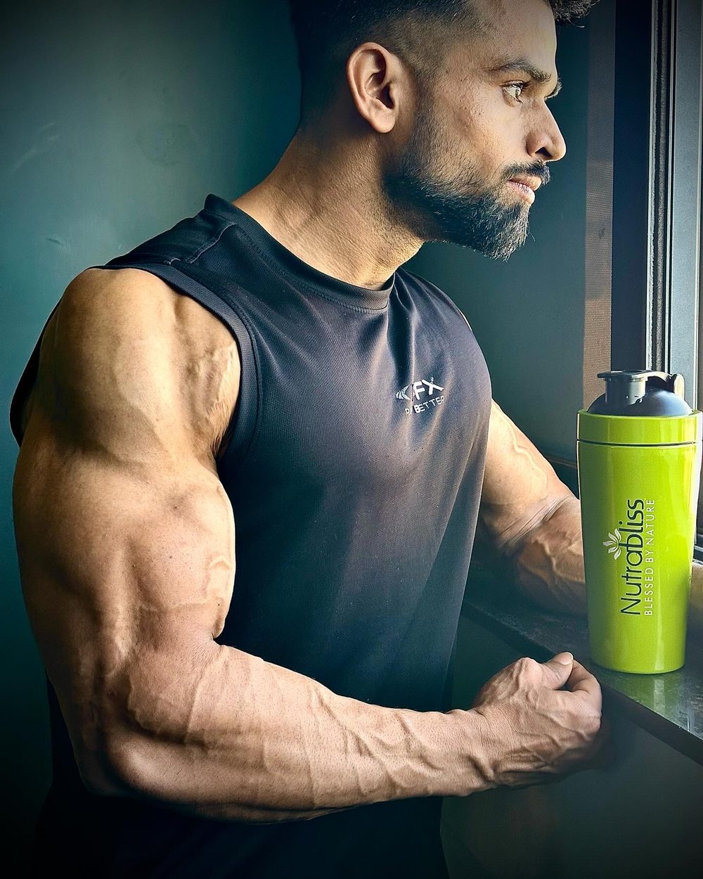 Amit by a window with his protein shaker